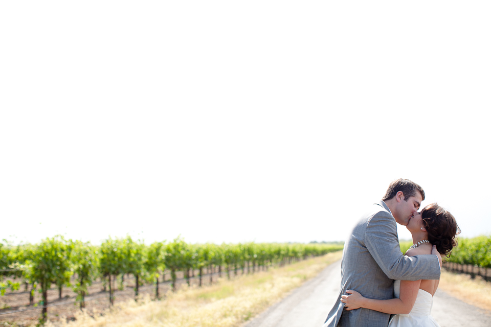 vineyard wedding, wedding photos in vineyard, couple kissing, leading lines